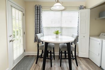 A dining room with a round table and chairs.